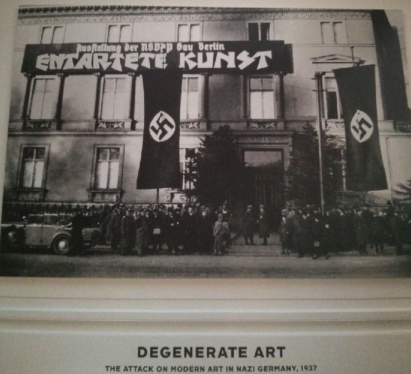 author's picture of banner at the Neue Galerie Exhibition of Degenerate Art, New York City, 2014. Banner is picture of original degenerate art exhibit in 1937.